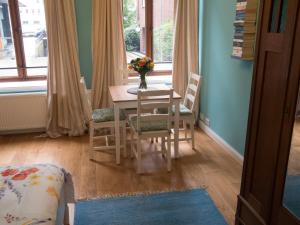 uma mesa de jantar e cadeiras com um vaso de flores em Schönes Apartment Blau zentral em Bremen