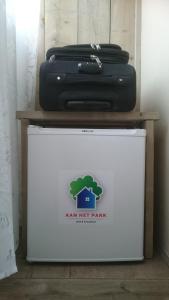 a suitcase sitting on top of a white refrigerator at B&B Aan het Park Eindhoven in Eindhoven