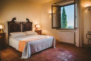 ein Schlafzimmer mit einem Bett und einem großen Fenster in der Unterkunft Fattoria Di Corsignano in Vagliagli