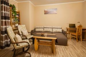 a living room with a couch and a table at Apartament Regina - Jantar in Kołobrzeg