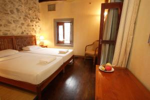 a bedroom with two beds and a plate of fruit on a table at Sala Prabang Hotel in Luang Prabang