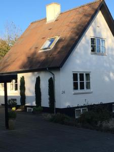 a white house with a brown roof at Heltoften Bed & Breakfast in Nykøbing Mors
