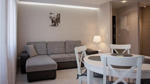 a living room with a couch and a table and chairs at Apartament Piano 2 in Racibórz
