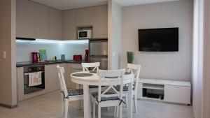 cocina con mesa y sillas y TV en Apartament Piano 2, en Racibórz