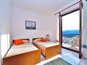 2 camas en un dormitorio con balcón en Apartment Bruna 653, en Rabac