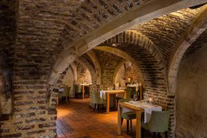 un comedor con mesas y sillas y una pared de ladrillo en Winselerhof - Oostwegel Collection, en Landgraaf