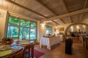 ein Esszimmer mit einem Tisch und einigen Fenstern in der Unterkunft Fattoria Di Corsignano in Vagliagli