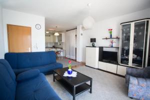 ein Wohnzimmer mit einem blauen Sofa und einem Tisch in der Unterkunft Apartments Zoran in Promajna