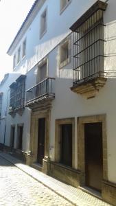a white building with balconies on a street at Piso en centro histórico in Jerez de la Frontera