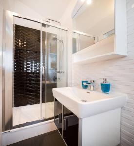 a white bathroom with a sink and a shower at Pavao Apartments in Vrboska