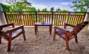 patio z 2 krzesłami i stołem na płocie w obiekcie Amun Ini Beach Resort & Spa w mieście Anda