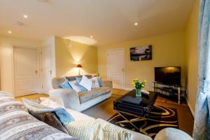 a living room with two couches and a tv at Apartment 20 Inchmarlo in Banchory
