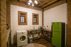 eine Küche mit einem grünen Kühlschrank, einer Waschmaschine und einem Trockner in der Unterkunft Harum Manis Villa in Jepara