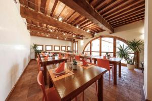 ein Restaurant mit Holztischen und roten Stühlen in der Unterkunft Pecora Vecchia - ColleMassari Hospitality in Cinigiano