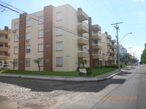 un edificio de apartamentos al costado de una calle en Apartamento Capão Novo, en Capão da Canoa