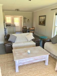 uma sala de estar com um sofá e uma mesa de centro em Olive Cottage em Franschhoek