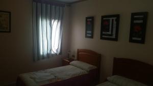 1 dormitorio con 2 camas y ventana en Hostal Don Pepe, en La Albuera