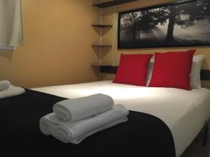 Una habitación de hotel con una cama con toallas. en Camping La Fundicion, en Cazalla de la Sierra