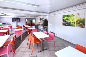 ein Esszimmer mit Tischen und roten Stühlen in der Unterkunft Hôtel Formules Club 2 in Cenon