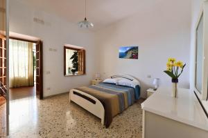 a bedroom with a bed and a vase of flowers at B&B Iris in Conca dei Marini