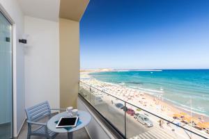 a room with a balcony with a view of the beach at Meltemi Coast Suites in Rethymno