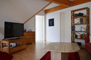 a living room with a tv and a table at Ferienwohnung Jäger in Grebenstein