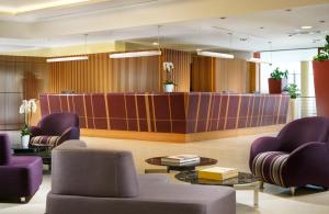 a lobby with purple chairs and a waiting room at UNAHOTELS Varese in Varese