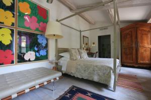 a bedroom with a bed and a bench in it at Pastis Hotel St Tropez in Saint-Tropez