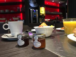 a table with two jars of honey and a cup of orange juice at SoBlue Hôtel in Antibes