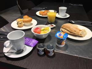 a table with plates of breakfast food and drinks at SoBlue Hôtel in Antibes