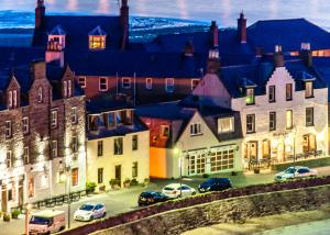 a group of buildings and cars parked in a street at Rooms at 31 in Stonehaven