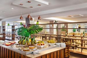 a restaurant with food on a counter with fruit on it at Rio Quente Resorts - Hotel Turismo in Rio Quente