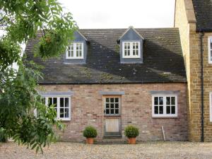 a brick house with two windows and a door at Weston Hill Farm in Moreton Pinkney +11 photos