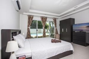 a bedroom with a large bed and a television at ViLLa JUNGLE 3 BEDROOMS in Kamala Beach +13 photos