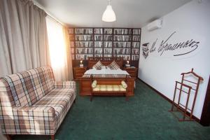 a bedroom with a bed and a couch and a book shelf at Vostok Hotel in Tyumen