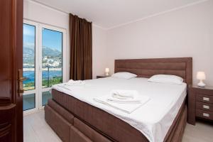 a bedroom with a large bed and a large window at Open Sea Apartments in Utjeha