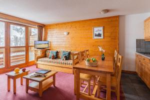 een woonkamer met een bank en een tafel bij travelski home select - Résidence Les Chalets du Galibier 4 stars in Valloire