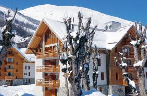um alojamento de turismo selvagem na neve com árvores em primeiro plano em travelski home select - Résidence Les Chalets du Galibier 4 stars em Valloire