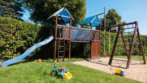 een park met een speeltuin met een glijbaan en schommels bij Pension Elmenhorst in Rostock