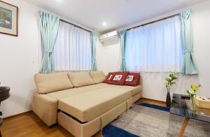 a couch in a living room with blue curtains at Haneda Luxury House in Tokyo