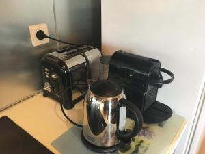 a tea kettle on a counter next to a toaster at Domaine de la Villa du Moulin de Champie - Plaine de Versailles in Plaisir