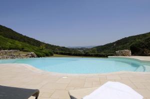 una piscina con patio y montañas de fondo en La Grotta dell'Eremita, en Gambassi Terme