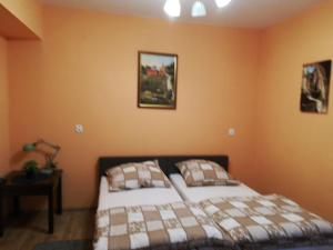 een slaapkamer met twee bedden en twee foto's aan de muur bij Pokoje Goscinne Lawenda II in Sandomierz
