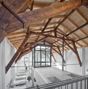 a large room with a wooden ceiling with beams at Albergue Santiago Apostol in Logroño