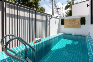 a swimming pool next to a fence with a swimming pool at Kamala Beach House - 1 min walk to beach in Kamala Beach