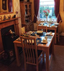 een eetkamer met een tafel en stoelen en een open haard bij Heathfield Bed and Breakfast in Whitby
