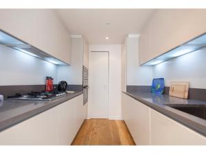 エディンバラにあるElegant & Modern Apartment in Central Edinburghのキッチン(白いキャビネット、カウンタートップ付)
