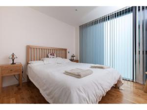 エディンバラにあるElegant & Modern Apartment in Central Edinburghのベッドルーム1室(大型ベッド1台、タオル付)