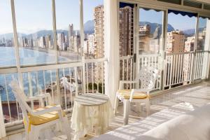 ベニドルムにあるApartamentos Halcónのベッドルーム(白い椅子付)、景色を望むバルコニーが備わります。