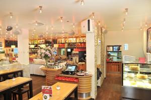 a restaurant with tables and a counter in a store at Stadthotel Langenfeld in Langenfeld